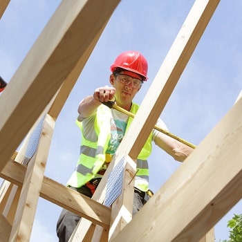 Builder working on roof of house